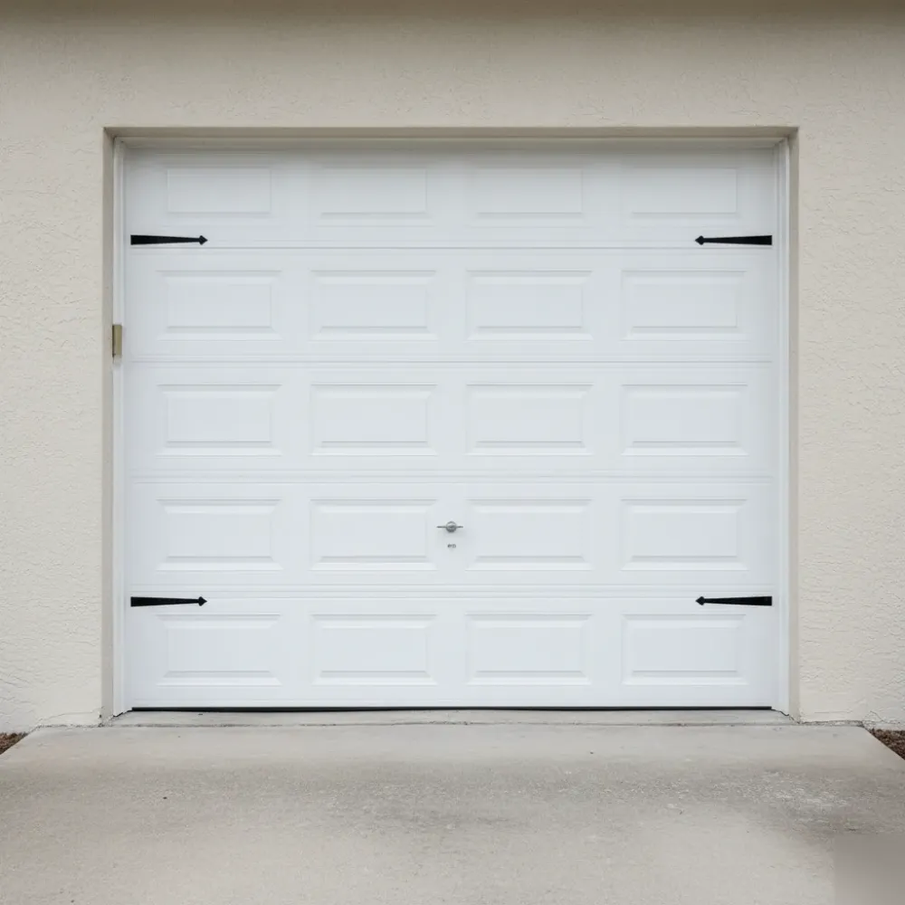 Newly installed white raised-panel garage door with brushed-steel hardware sits flush on a stucco home garage in Hallandale