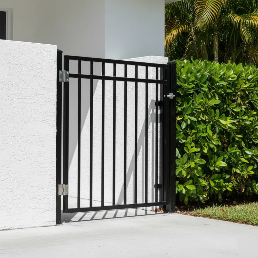 Repaired aluminum swing gate with clean black powder-coated pickets and new stainless steel hinges stands flush against a