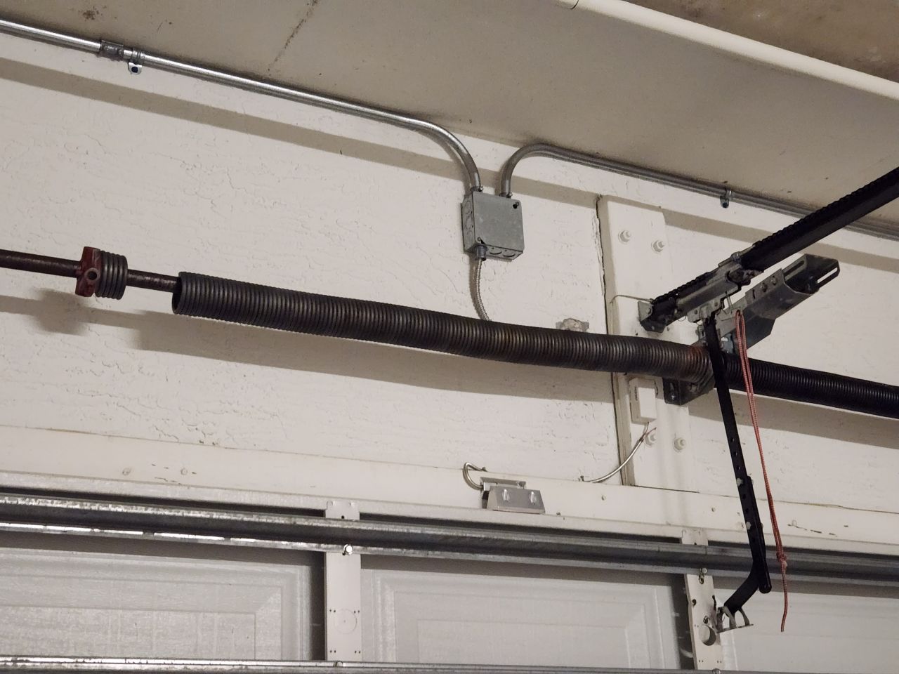 Close-up of broken garage door torsion spring coil fracture point